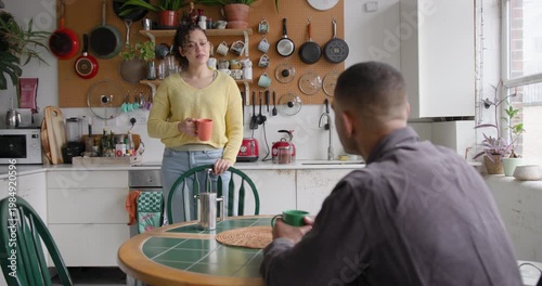 Young couple chatting over coffee in a kitchen