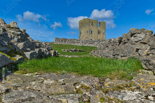 Konstfotografi A historic stone castle ruin with a central tower stands against a bright blue s