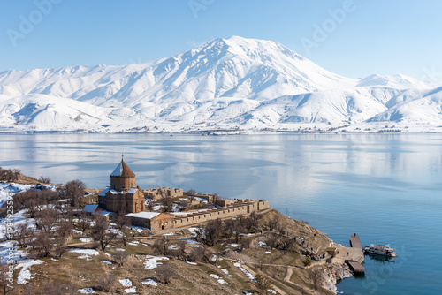 View of Akdamar Island with Holy Cross Church, Lake Van and snow-covered mountains, highlighting cultural heritage and winter landscape in eastern Türkiye