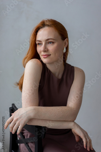 Portrait of young redhead woman with freckles in studio. Sensual expressive happy woman