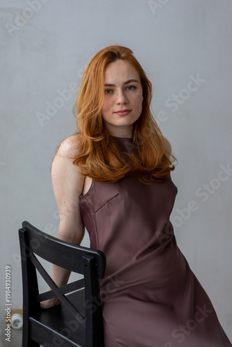 Portrait of young redhead woman with freckles in studio. Sensual expressive happy woman