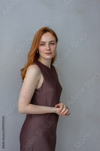Portrait of young redhead woman with freckles in studio. Sensual expressive happy woman