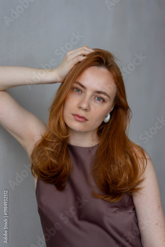 Portrait of young redhead woman with freckles in studio. Sensual expressive happy woman