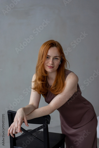 Portrait of young redhead woman with freckles in studio. Sensual expressive happy woman