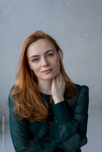 Portrait of young redhead woman with freckles in studio. Sensual expressive happy woman