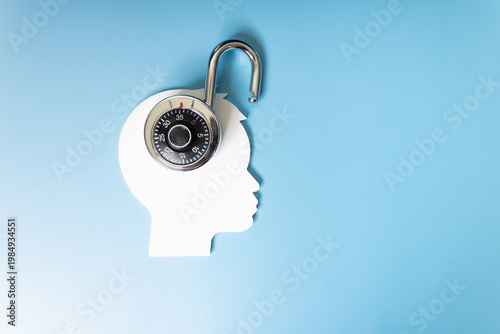 Concept of intelligence and good mental health, open padlock simulating openness and knowledge, silhouette of a person on a blue background