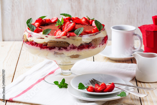 Strawberry Tiramisu Trifle Dessert with Cream Layers and Mint in Glass Bowl