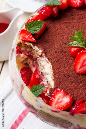 Strawberry Tiramisu Trifle Dessert with Cream Layers and Mint in Glass Bowl