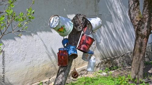 Vintage Enamel Buckets and Milk Cans on a Wooden Post