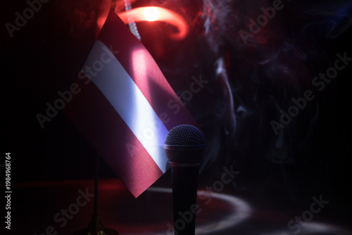 Microphone on a background of a blurry flag of Austria close-up. dark table decoration