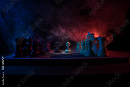 Chess board game concept of business ideas and competition. Chess figures on a dark background with smoke and fog.