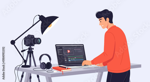 Young man editing video on a laptop with camera and lighting equipment on a desk.