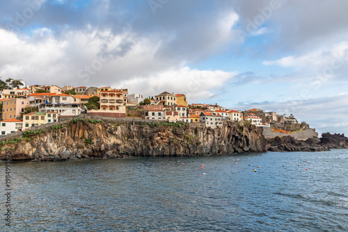 Houses on the edge of a cliff right on the ocean. The village of Camara de Lobos in Madeira on the Atlantic coast
