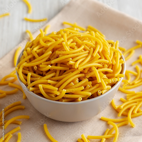 Organic Dry Raw Macaroni Pasta in a Bowl, side view.