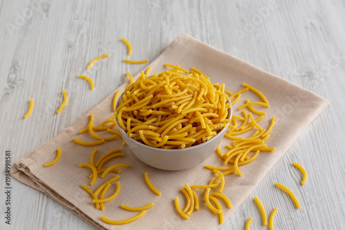 Organic Dry Raw Macaroni Pasta in a Bowl, side view.