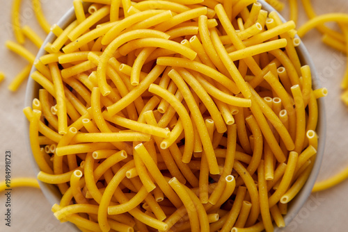 Organic Dry Raw Macaroni Pasta in a Bowl, top view. Close-up.