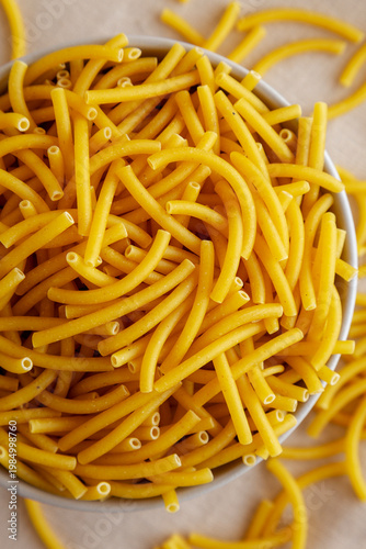 Organic Dry Raw Macaroni Pasta in a Bowl, top view. Close-up.