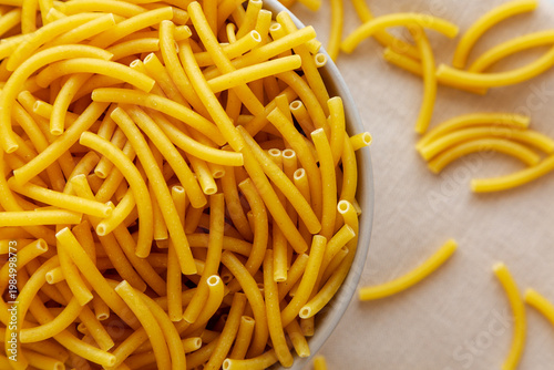 Organic Dry Raw Macaroni Pasta in a Bowl, top view. Close-up.