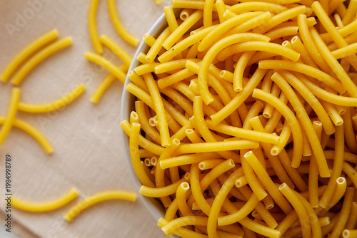 Organic Dry Raw Macaroni Pasta in a Bowl, top view. Close-up.