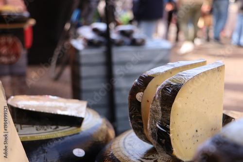 Large wheels of Dutch cheese stacked at a busy Haarlem market.