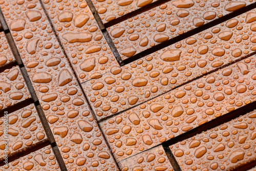 Close-up of rain droplets on a wet wooden table surface