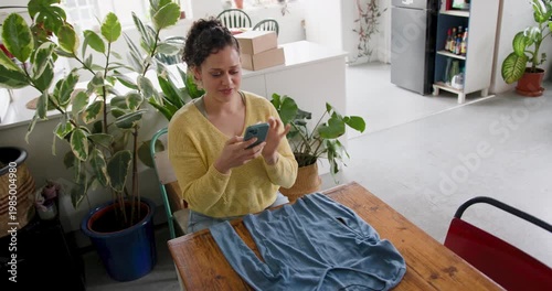 Young woman taking a photo to sell clothes online