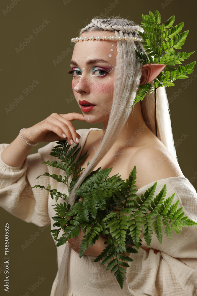 Fototapeta premium Beautiful elf girl with floral decor on dark olive background