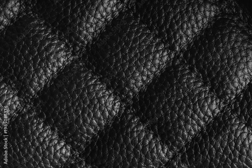 Obraz premium Close up, macro of black quilted leather texture with stitched diamond pattern, luxury material surface shining metal effect for fashion, upholstery or design wallpaper, rough, relief background