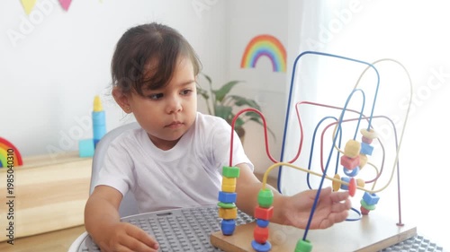 Latin kid playing with didactic toys at preschool or daycare room. Child learning at kindergarten