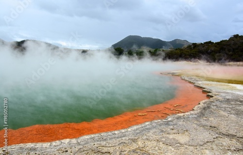 steam and the colorful hot springs  of  the champagne pool in the waiotapu thermal wonderland near rotorua, on the north island of new zealand,  on a summer day