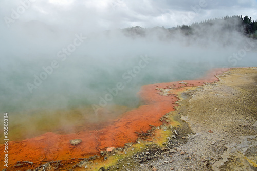 steam and the colorful hot springs  of  the champagne pool in the waiotapu thermal wonderland near rotorua, on the north island of new zealand,  on a summer day