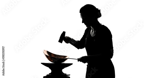 A black silhouette of a woman working with hot metal in a workshop