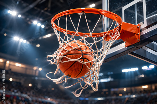 Basketball passing through hoop net in brightly lit indoor arena