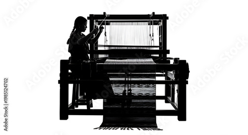 A woman in silhouette weaving fabric on a traditional loom