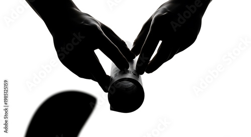 A silhouette of hands holding a cylindrical object against a white background