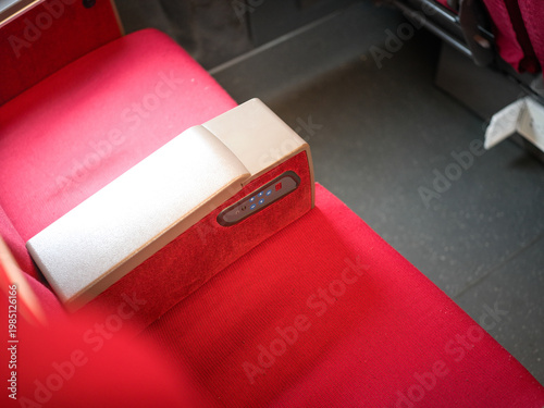 Foto Close up of red seat armrest control panel in high speed train carriage