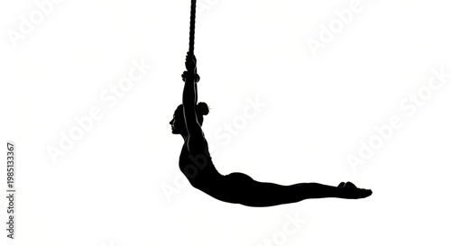 A black silhouette of a woman performing aerial yoga while suspended in the air by a rope