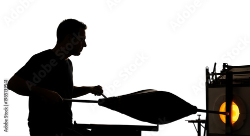 A silhouette of a man working with molten glass in a furnace