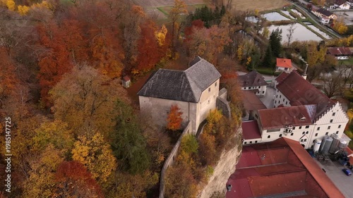 Aerial video of Schloss Stein an der Traun in Traunstein district, Bavaria, Germany. High castle on Nagelfluhwand surrounded by autumn colors. Luftaufnahme von Schloss Stein, Bayern, Deutschland