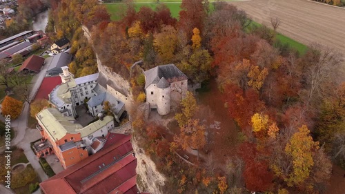 Scenic aerial of Schloss Stein an der Traun, Bavaria, Germany. Historic fortress on Nagelfluhwand above Traun valley surrounded by golden autumn trees. Luftaufnahme von Schloss Stein an der Traun 