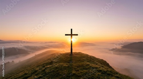 Silhouette of Christian cross on mountain peak at sunrise with golden sunlight breaking through thick fog and misty valley