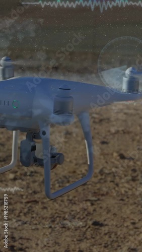 Vertical video: Pilot sending command drone hovering moving right over plain, HUD showing mapping