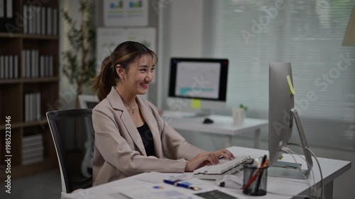 Young Businesswoman Working on Computer in Modern Office Setting