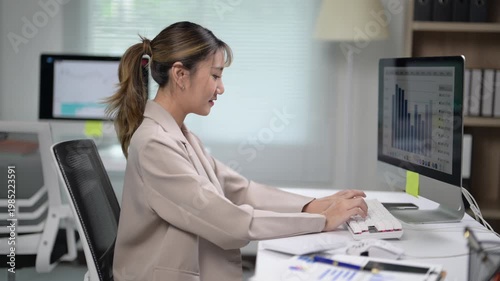 Professional Woman Working at Desk with Computer and Graphs