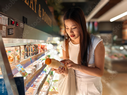 Konstfotografi Woman shopping for groceries reading food label in supermarket