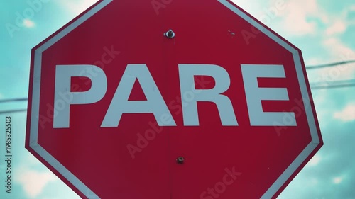 Foreground focus on a bright red PARE stop sign