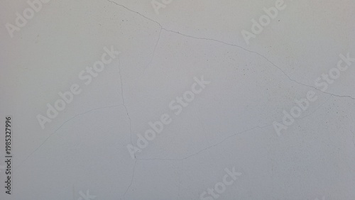 Close-up of detailed cracking patterns on a weathered white plaster wall