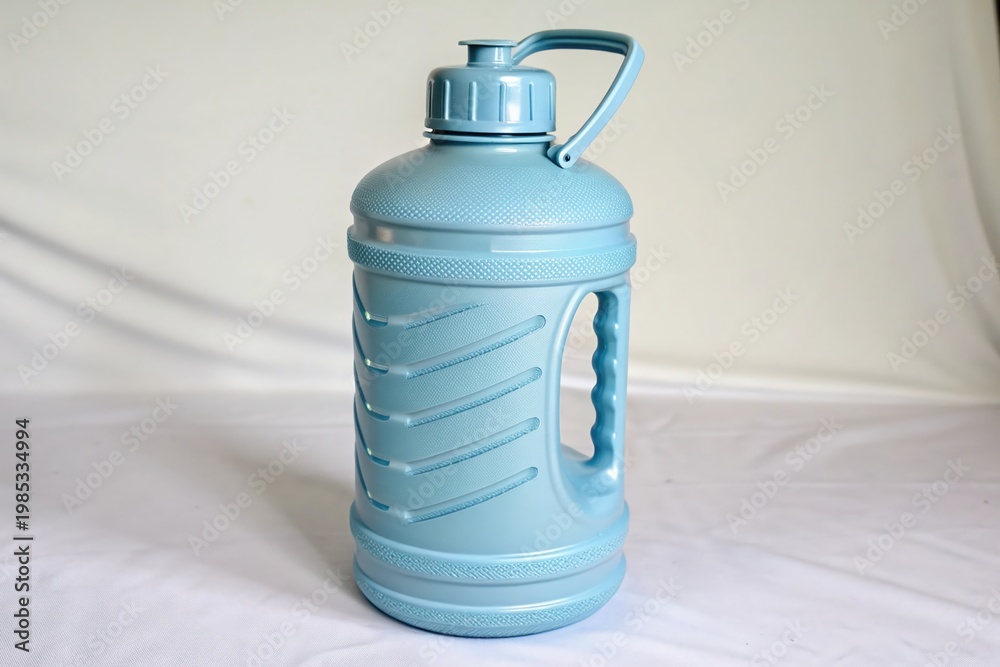 Obraz premium A blue water bottle with a handle sits on a concrete step