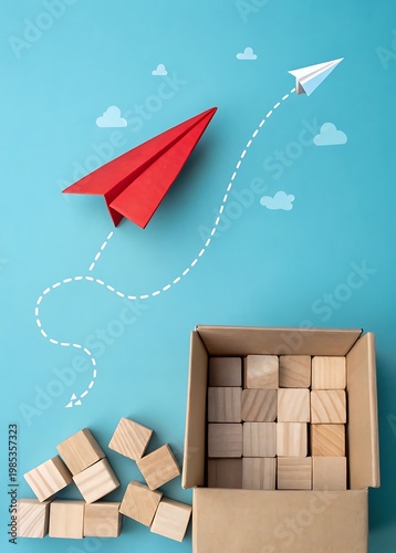 Red and white paper airplanes flying from box of wooden blocks with clouds image