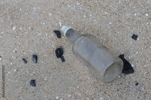Plastic water bottles thrown on the sand, plastic pollution and broken bottle. Climate change issues with the plastic wastes and bottle waste.